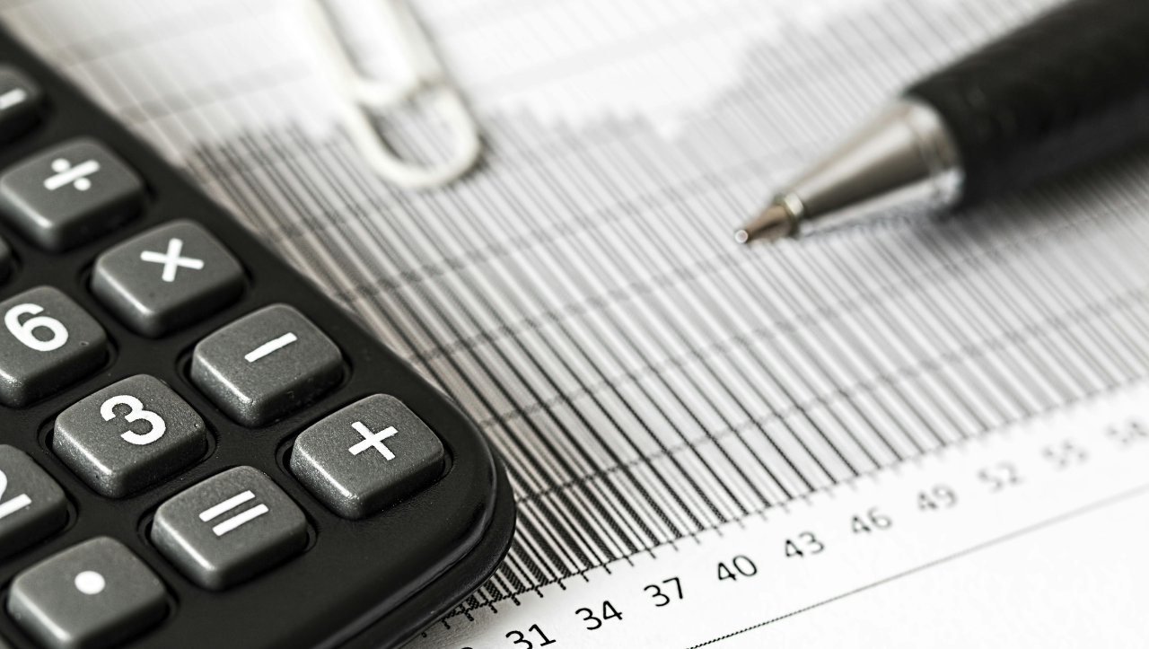 calculadora, boligrafo y documentos